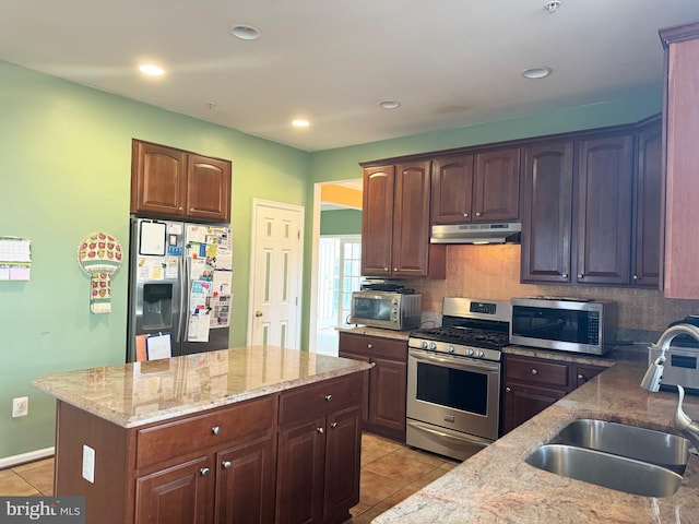 kitchen with decorative backsplash, light stone countertops, sink, and appliances with stainless steel finishes