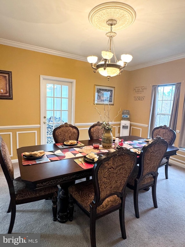 dining room with carpet, crown molding, and an inviting chandelier