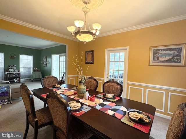 carpeted dining room with crown molding and an inviting chandelier