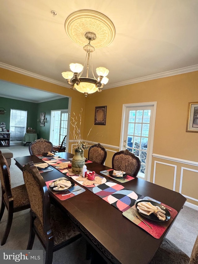 dining room with carpet, crown molding, and a notable chandelier