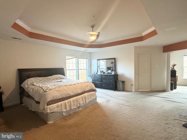 carpeted bedroom featuring a tray ceiling, ceiling fan, and ornamental molding