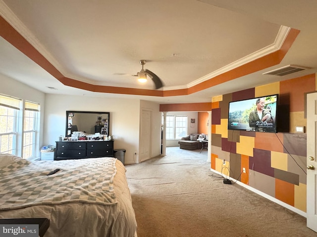 carpeted bedroom with ceiling fan, ornamental molding, and a tray ceiling