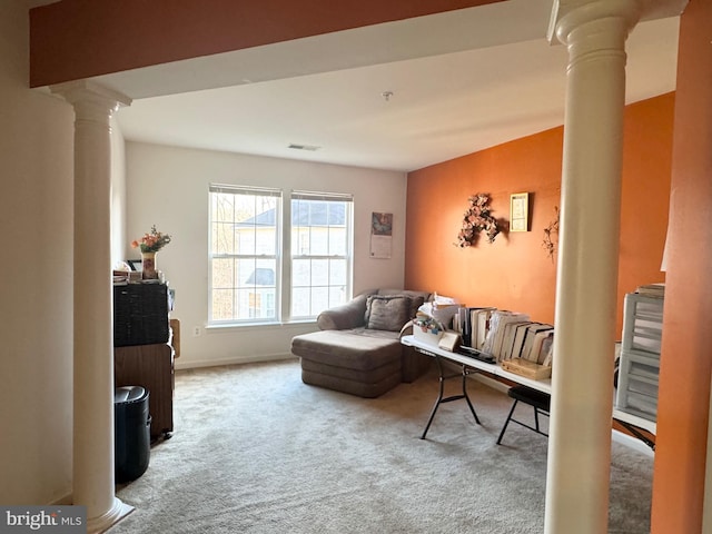 interior space featuring decorative columns and carpet floors