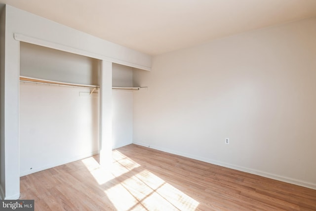 unfurnished bedroom with a closet and light hardwood / wood-style floors