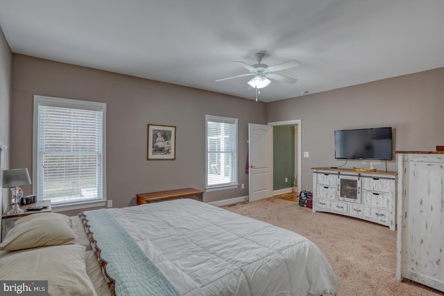 bedroom with light colored carpet, multiple windows, and ceiling fan