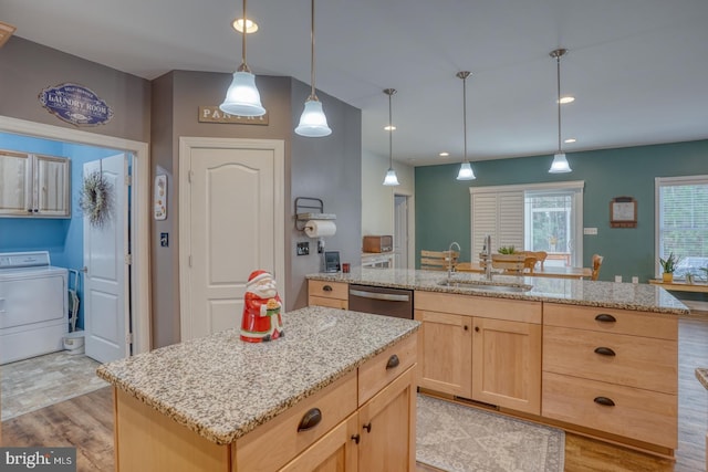 kitchen featuring light brown cabinets, a center island with sink, washer / clothes dryer, and sink