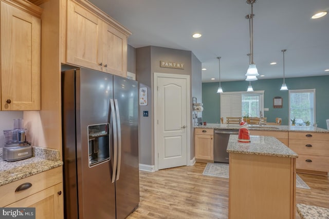 kitchen featuring light brown cabinets, hanging light fixtures, stainless steel appliances, kitchen peninsula, and light wood-type flooring