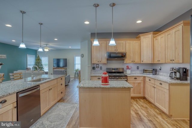 kitchen with ceiling fan, a center island, light brown cabinets, stainless steel appliances, and light wood-type flooring