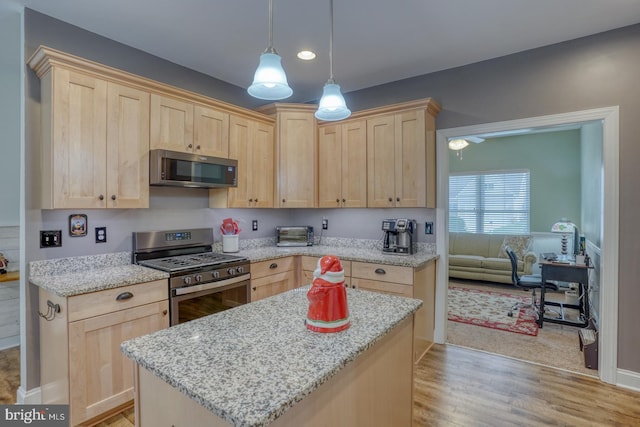 kitchen featuring appliances with stainless steel finishes, light wood-type flooring, light stone counters, and light brown cabinetry