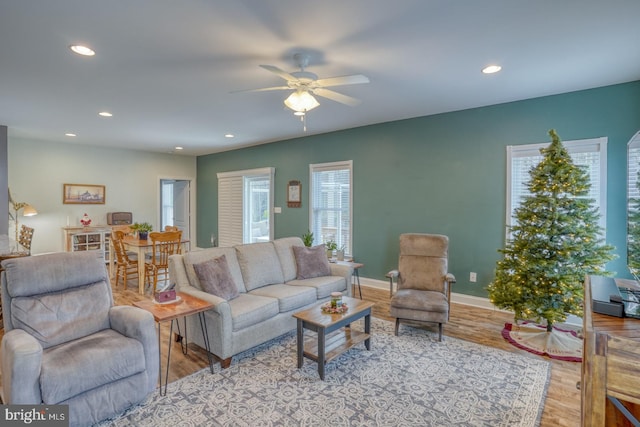 living room with light wood-type flooring and ceiling fan