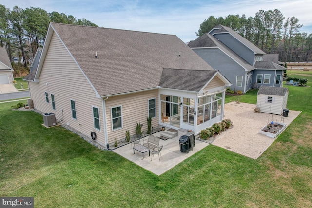 rear view of house featuring a patio, a storage unit, a lawn, and a sunroom