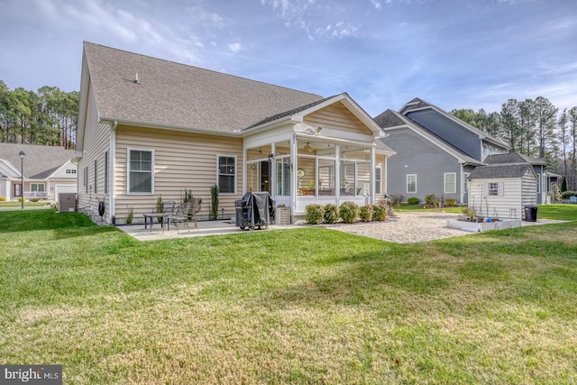 rear view of house featuring a sunroom, a patio, ceiling fan, and a lawn