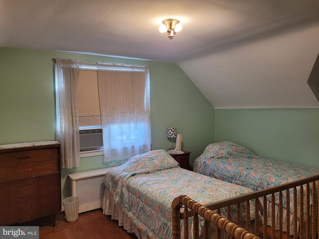 bedroom with radiator, hardwood / wood-style floors, cooling unit, and vaulted ceiling