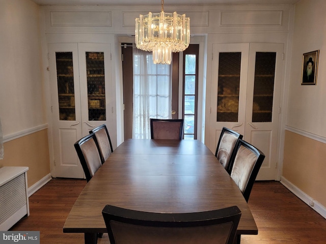 dining space with dark hardwood / wood-style flooring and an inviting chandelier