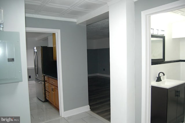 hallway featuring electric panel, sink, and light wood-type flooring