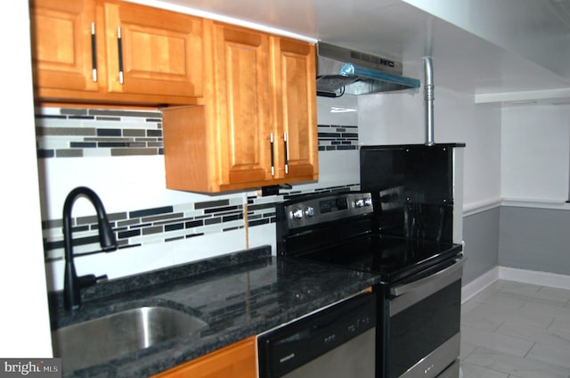 kitchen featuring sink, stainless steel appliances, ventilation hood, dark stone countertops, and decorative backsplash