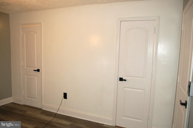 interior space featuring dark hardwood / wood-style flooring and a textured ceiling