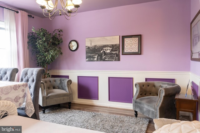 sitting room with hardwood / wood-style flooring and a notable chandelier