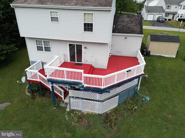 back of property featuring a yard, a shed, and a deck