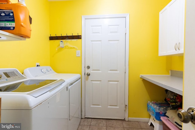 washroom featuring cabinets, light tile patterned floors, and washing machine and dryer