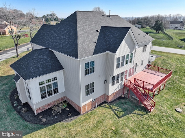 rear view of property featuring a yard and a deck