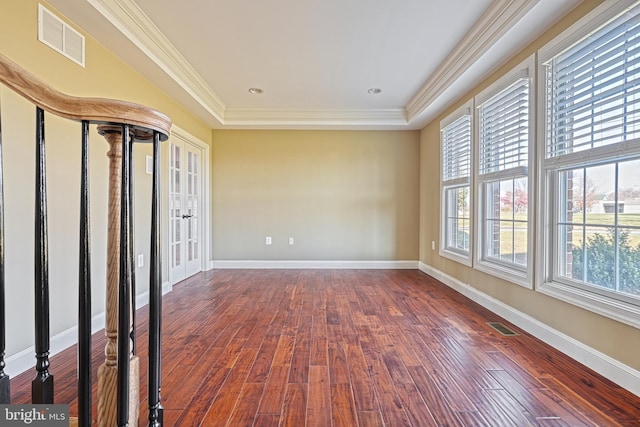 spare room with hardwood / wood-style floors, a tray ceiling, french doors, and ornamental molding