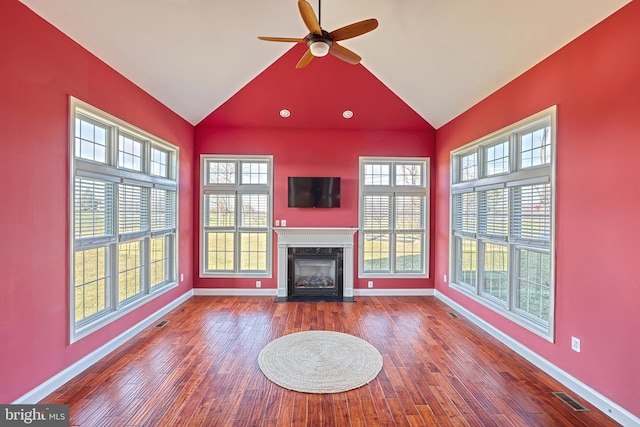 unfurnished living room with hardwood / wood-style floors, ceiling fan, lofted ceiling, and a high end fireplace