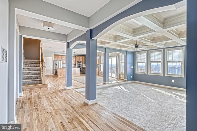 entryway featuring beamed ceiling, ceiling fan, a healthy amount of sunlight, and wood-type flooring