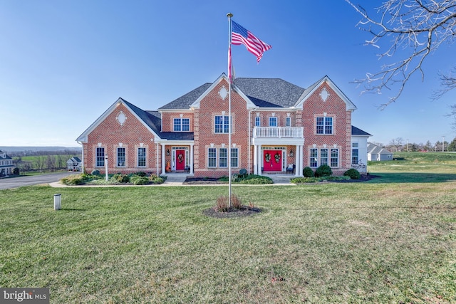 view of front of house featuring a balcony and a front lawn