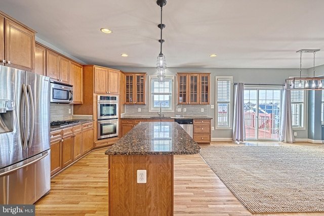 kitchen featuring a wealth of natural light, a center island, light hardwood / wood-style flooring, and appliances with stainless steel finishes