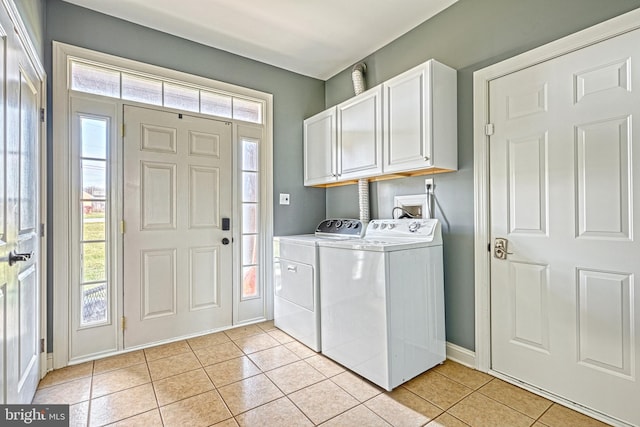 washroom with cabinets, light tile patterned floors, and washing machine and dryer