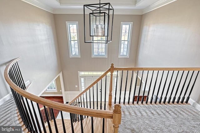 staircase featuring crown molding and a chandelier