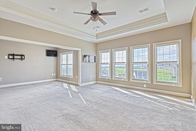 carpeted empty room featuring a raised ceiling, ceiling fan, and ornamental molding