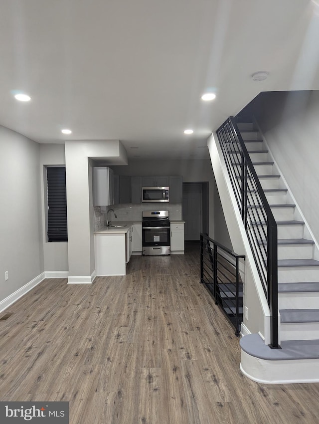 unfurnished living room featuring light hardwood / wood-style floors and sink