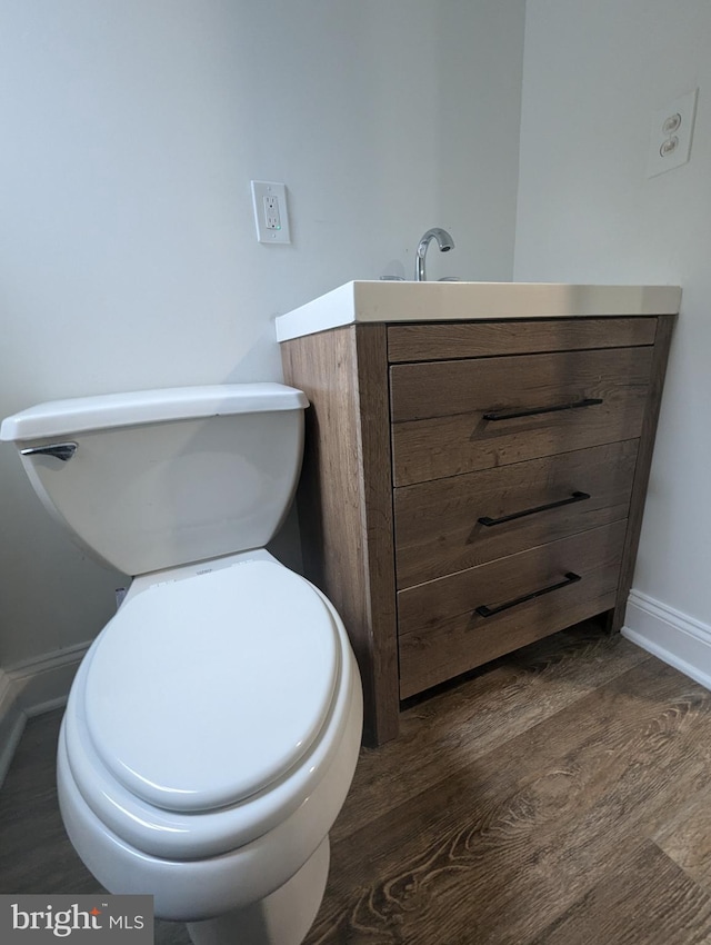 bathroom with hardwood / wood-style floors, vanity, and toilet