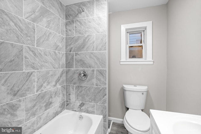 full bathroom with vanity, tiled shower / bath, wood-type flooring, and toilet