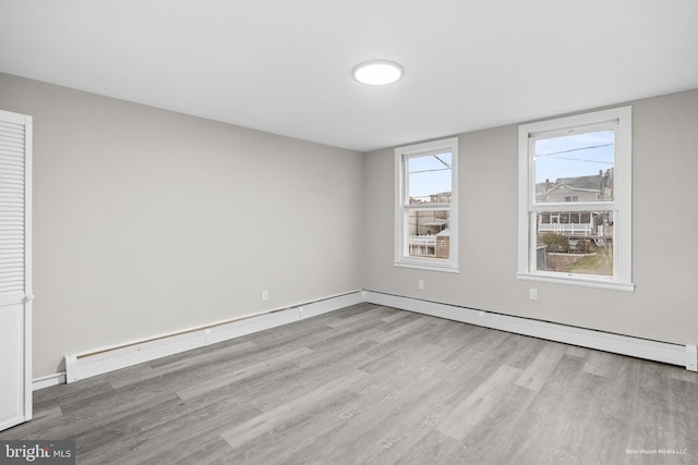 unfurnished room with light hardwood / wood-style flooring and a baseboard radiator