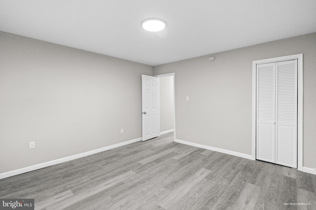 unfurnished bedroom with light hardwood / wood-style floors and a closet