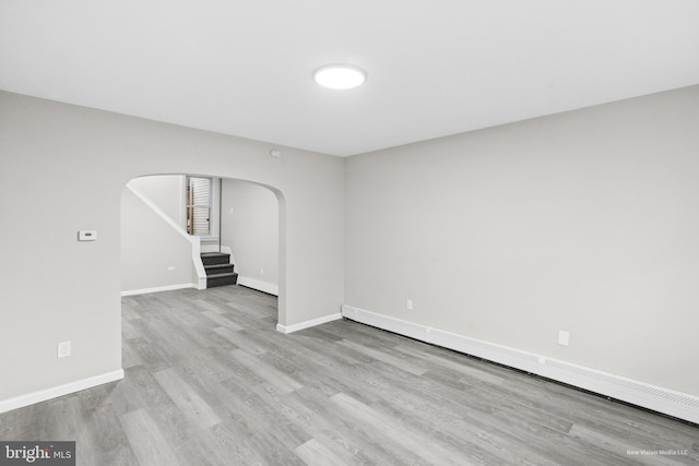 unfurnished living room with light hardwood / wood-style flooring and a baseboard radiator