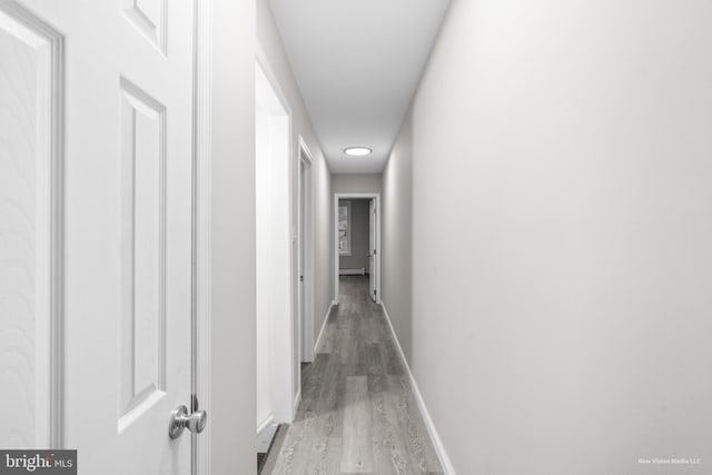 hall featuring wood-type flooring and baseboard heating