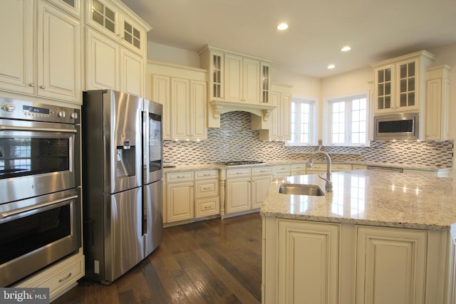 kitchen with light stone countertops, appliances with stainless steel finishes, dark hardwood / wood-style flooring, and sink