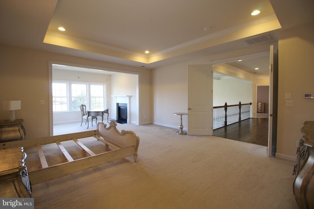 carpeted living room featuring a raised ceiling and crown molding