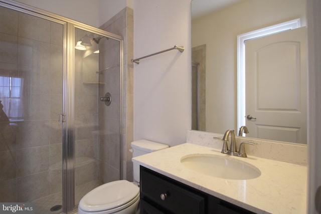 bathroom featuring walk in shower, vanity, and toilet