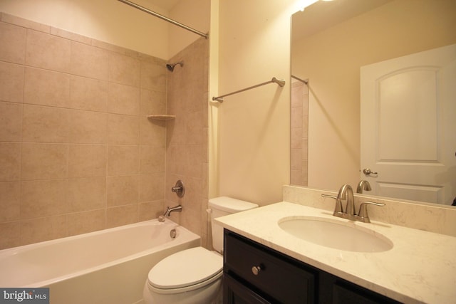 full bathroom featuring tiled shower / bath combo, toilet, and vanity