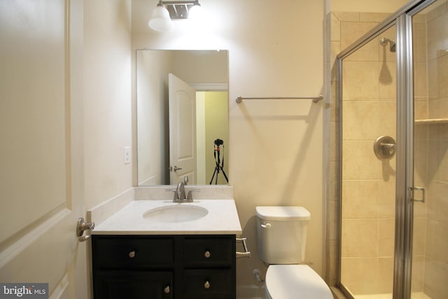 bathroom with vanity, toilet, and an enclosed shower