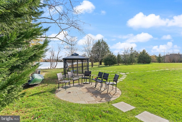 view of yard featuring a gazebo, a water view, and a patio area