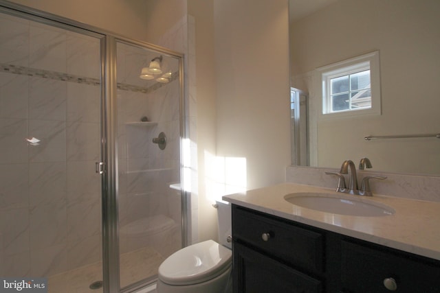 bathroom featuring vanity, toilet, and walk in shower