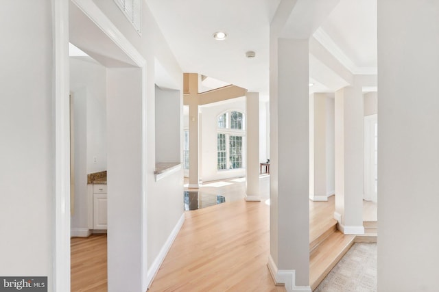 corridor with crown molding and light hardwood / wood-style floors