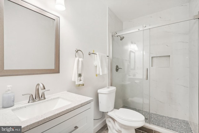 bathroom with vanity, toilet, and a shower with door