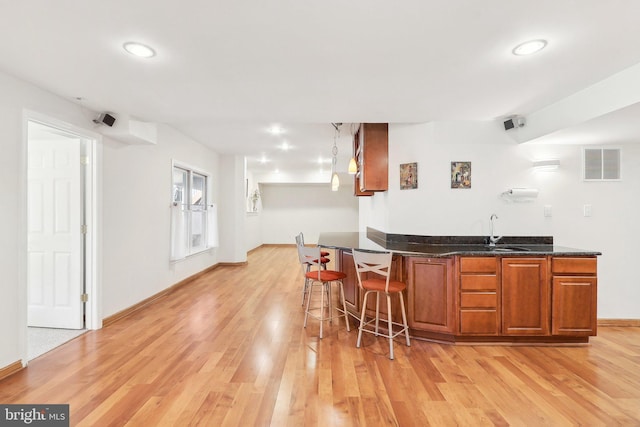 bar featuring light hardwood / wood-style floors and sink